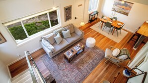 A spacious living area with a sofa, coffee table, and dining table. There is a staircase leading to an upper level. - 2bd, 2BA Ketchum Condo Newly Remodeled & Central (Ketchum)