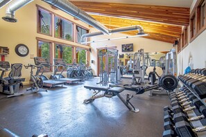 A gym with various exercise equipment, large windows, and a wooden ceiling. - 2BD Sweetwater Condo - Community Park, Pool + Hot Tub (Hailey)