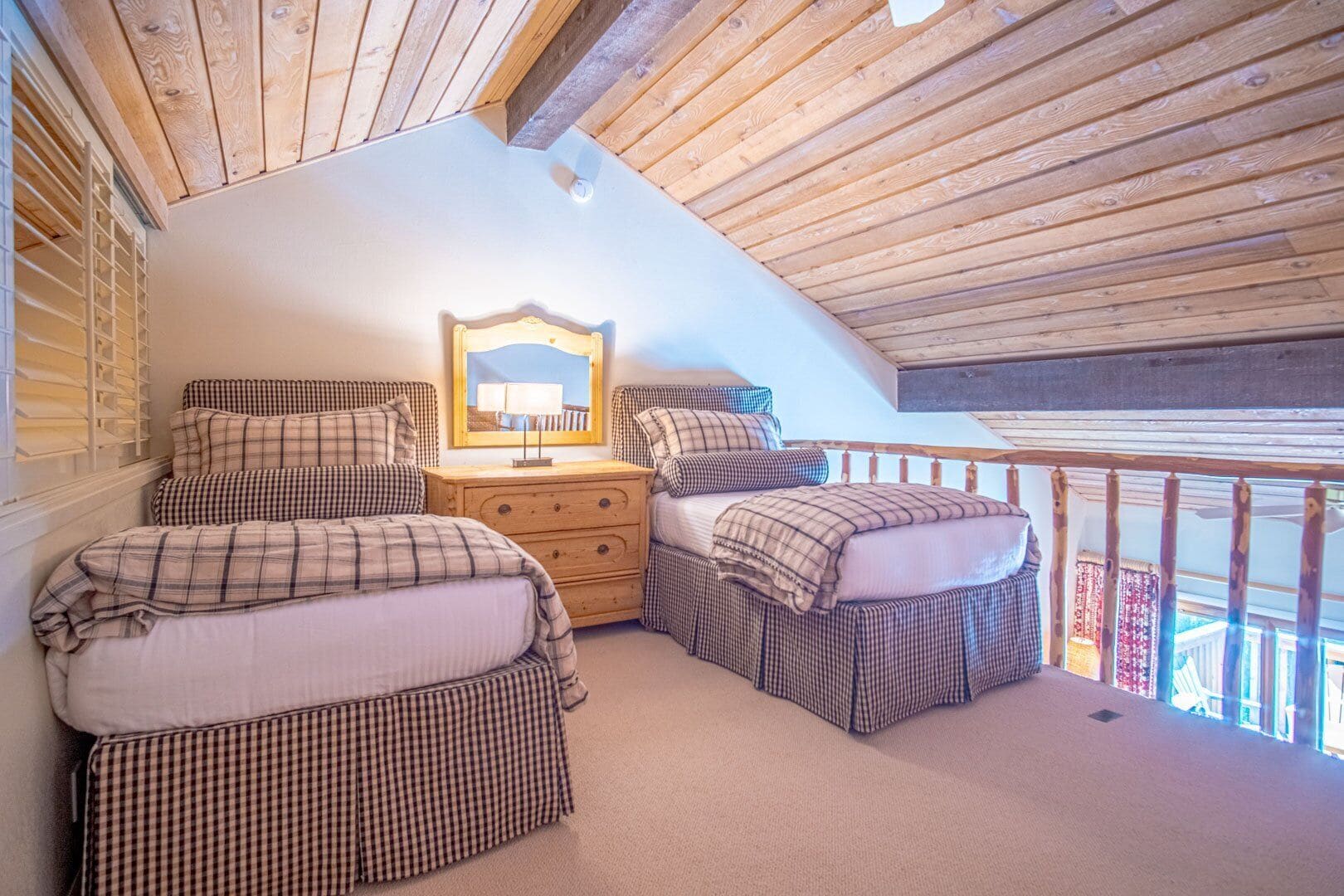 Une chambre confortable avec deux lits, une commode et un miroir.