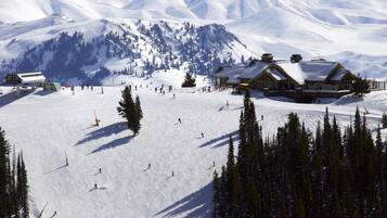 Une station de ski dotée de plusieurs chalets, de nombreuses pistes de ski et offrant un paysage montagneux en toile de fond.