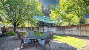 A patio with a table and chairs, a grill, and a wooden fence. - In the Heart of Hailey; Private Pet-friendly 3 Bedroom Home With Garage (Hailey)