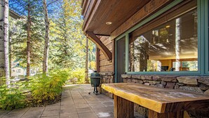 A wooden bench outside a building with stone walls and a large window. - Lux Baldy Vista at Warm Springs Home + Hot Tub - Walk to SV Ski Lifts (Ketchum)