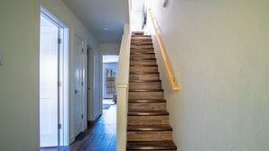 Un escalier en bois, doté d’une rampe, menant à l’étage supérieur.