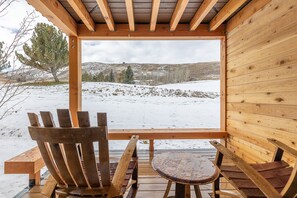 Une cabane en bois offrant une vue sur un paysage enneigé.