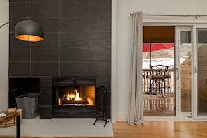 A modern living room with a fireplace, a wooden table, and a chair. - Sunburst in Sun Valley! Modern Family Getaway in Elkhorn (Sun Valley)