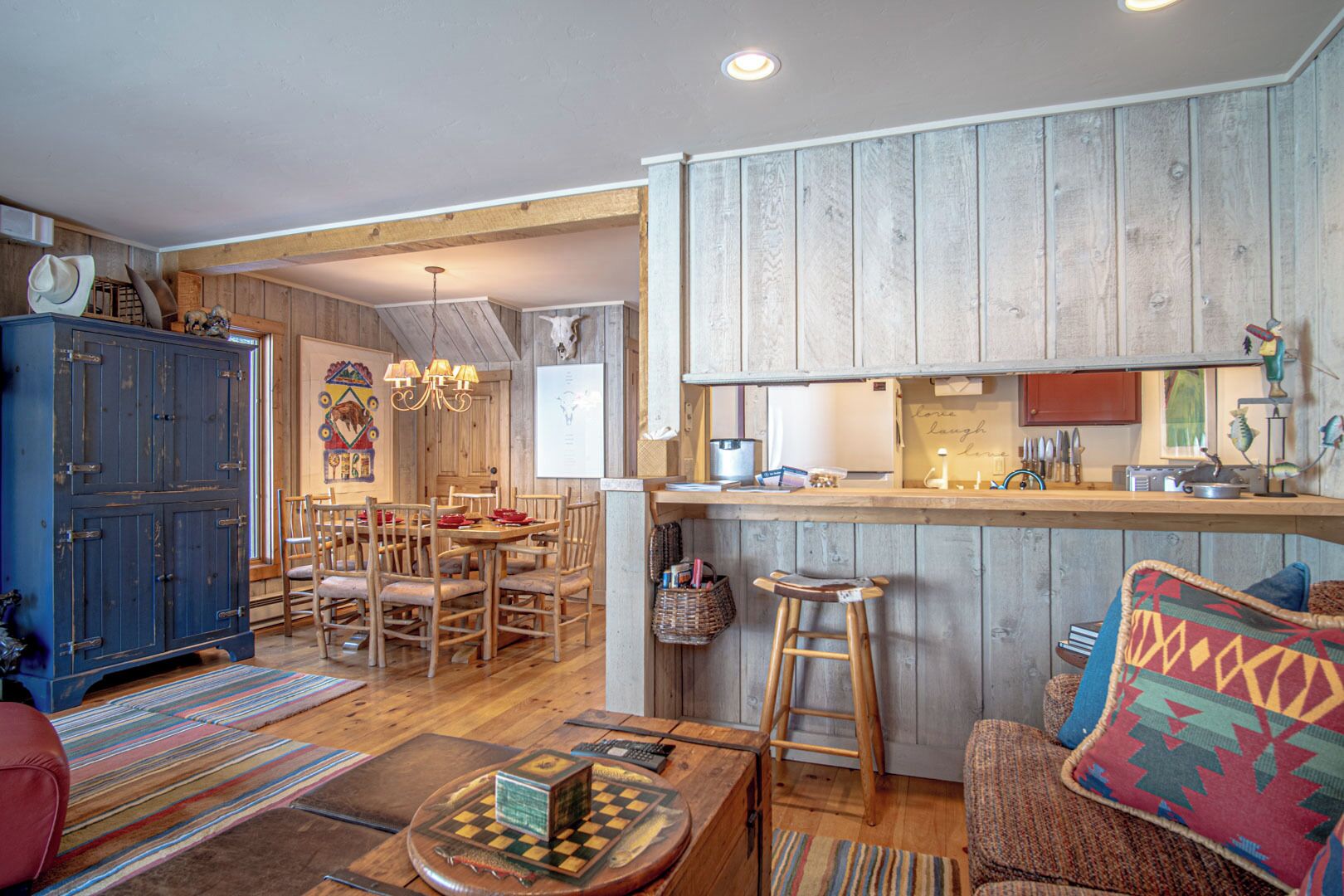 A rustic interior with a wooden dining area, a bar, and a cozy seating area.