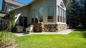 A house with a stone foundation, a patio with outdoor furniture, and a well-maintained lawn. - Sunflower Lane - 4BD Sun Valley Retreat + Resort Amenities (Sun Valley)