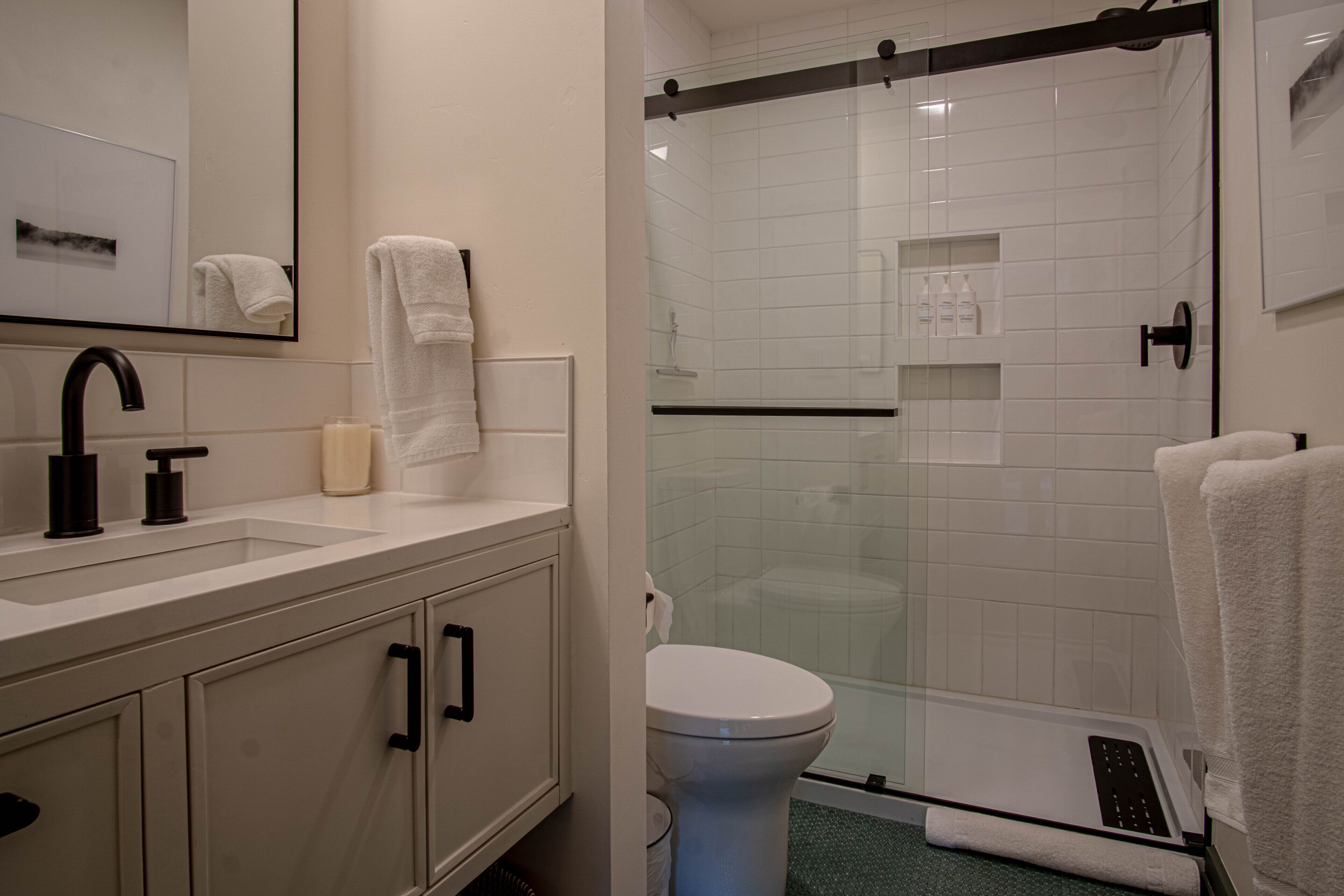 Une salle de bain moderne avec une douche à parois de verre, un lavabo blanc et des toilettes.