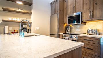 Bloc d'apartaments, diversos llits, balcó, vistes a la muntanya (Stonehenge Condo #5) | Cuina privada | Una taula de menjador