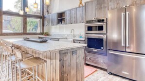 Una cucina moderna con mobili in legno, un frigorifero in acciaio inossidabile e un forno integrato.
