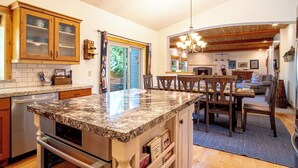 A spacious kitchen with granite countertops, wooden cabinets, and a central island. - Cranbrook Cottage - Family Home + Hot Tub + Pool Table (Hailey)