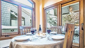 A dining table set for two with a wine bottle, glasses, and bread. - Sv154 - Walk to Lifts & Town - Hot Tub & Pool (Ketchum)
