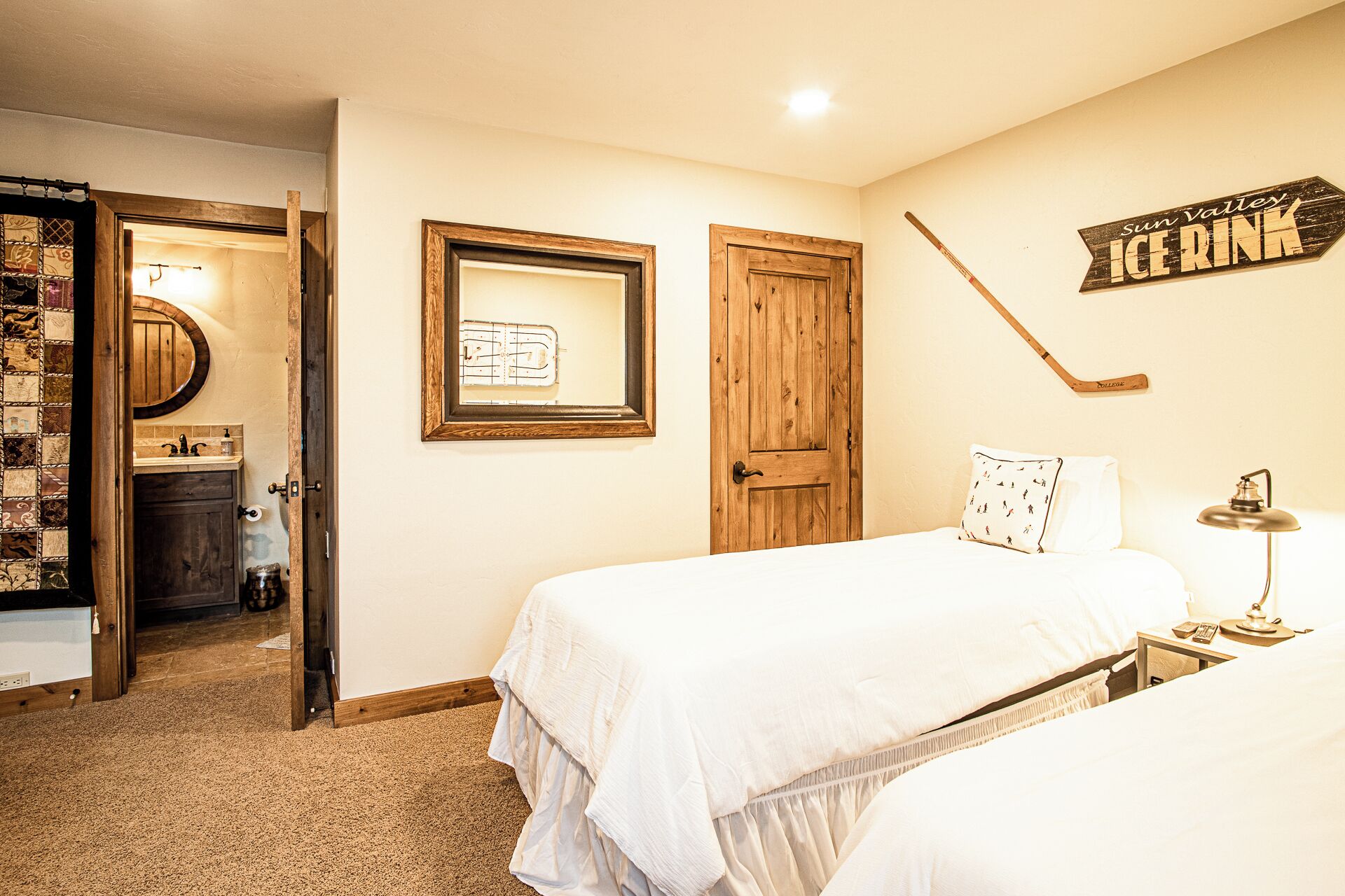 Un dormitorio con cama, mesita de noche, lámpara, un stick de hockey y un cartel que dice "Sun Valley ICE HOCKEY".