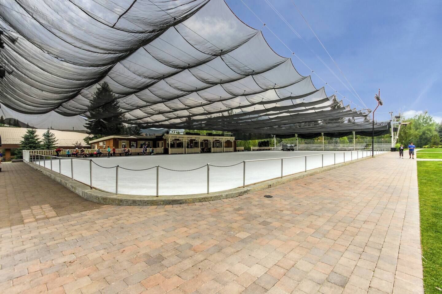 Un stade de plein air pour les sports, doté d’une zone de sièges couverte et d’une allée pavée.