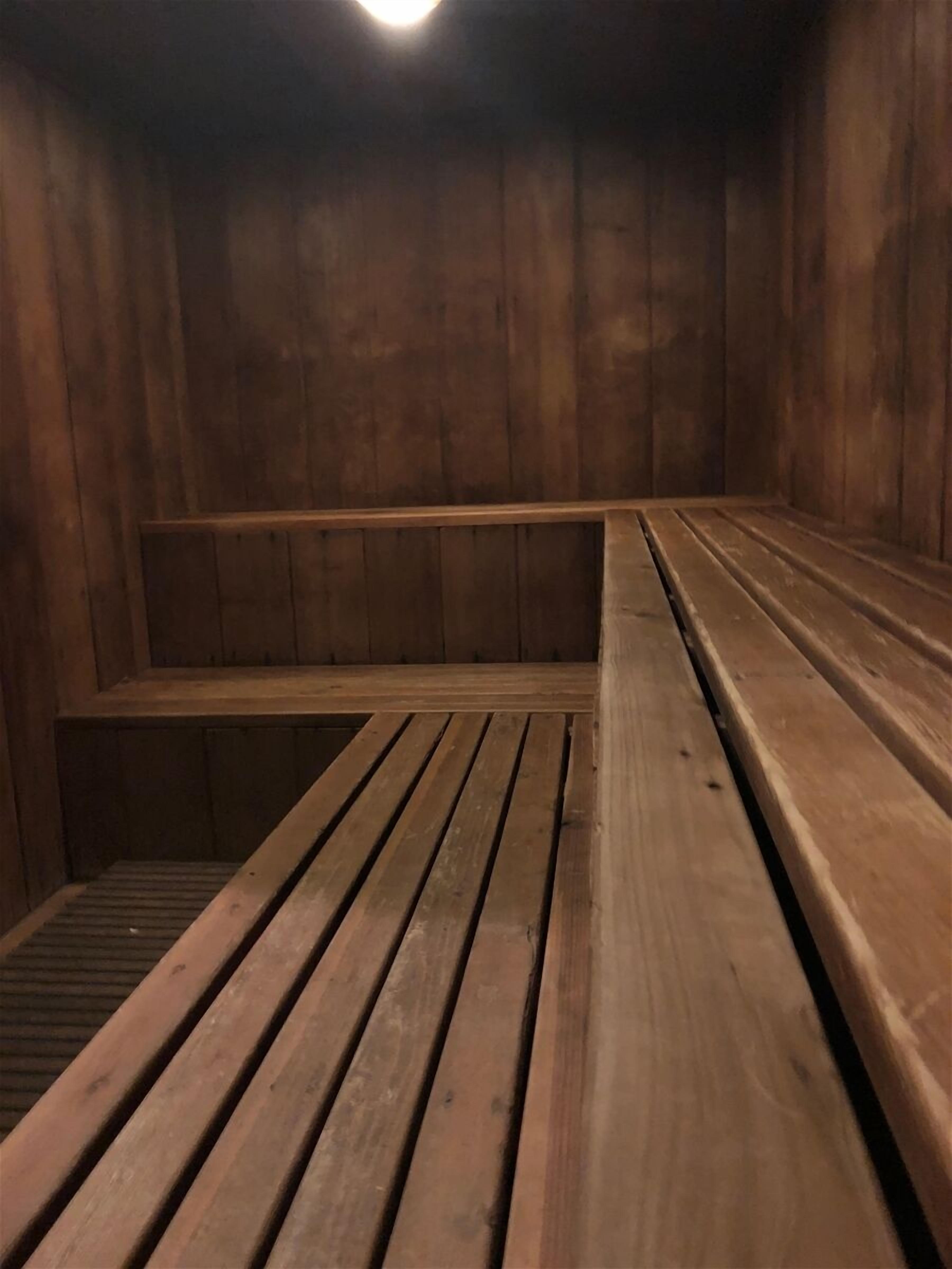 A sauna room with wooden benches and a slatted floor.