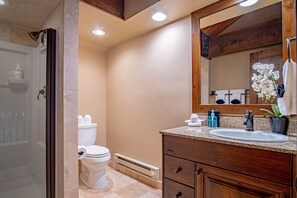 Un baño con ducha, inodoro, lavabo y tocador.