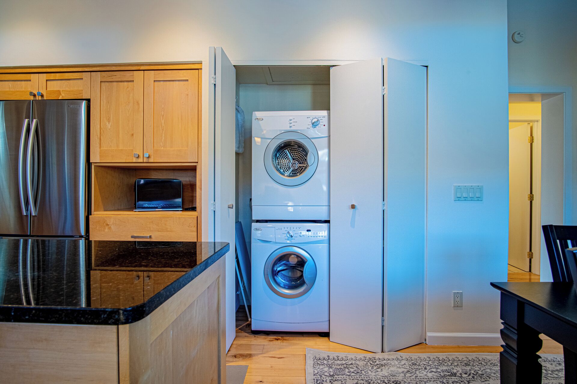 A compact kitchen with a built-in refrigerator, a microwave, and a washing machine.