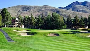 A golf course with bunkers and a clubhouse in the background. - Bonne Vie Condo - Heart of Elkhorn + Resort Amenities (Sun Valley)