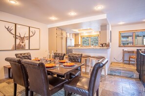 A dining area with a large table, leather chairs, and a framed deer head on the wall. - Ridge Condo - Modern Luxury Condo W/resort Amenities (Sun Valley)