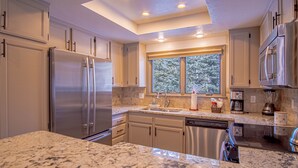 A modern kitchen with granite countertops, stainless steel appliances, and a skylight. - Ridge Condo - Modern Luxury Condo W/resort Amenities (Sun Valley)
