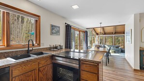 Uma cozinha moderna com uma ilha grande, armários de madeira e um forno embutido.