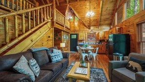A wooden cabin interior with a staircase, a dining area, and a kitchen. - Secluded Cabin for 4 w/ Private Hot Tub & Jacuzzi! (Sevierville)