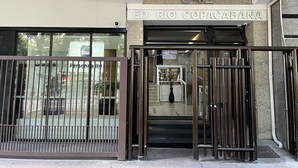 Indgangen til en bygning med en metalport, et skilt der siger "ED RIO COPACABANA", og nummeret "542" over døren.