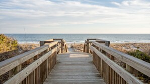 A wooden boardwalk leading to the beach with a clear view of the ocean. - Steps to beach with views galore! (Emerald Isle)