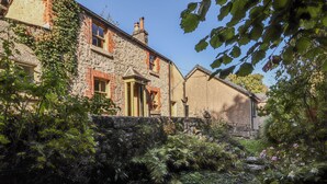 A stone house with a garden and a small stream. - Rock Cottage (Milnthorpe)
