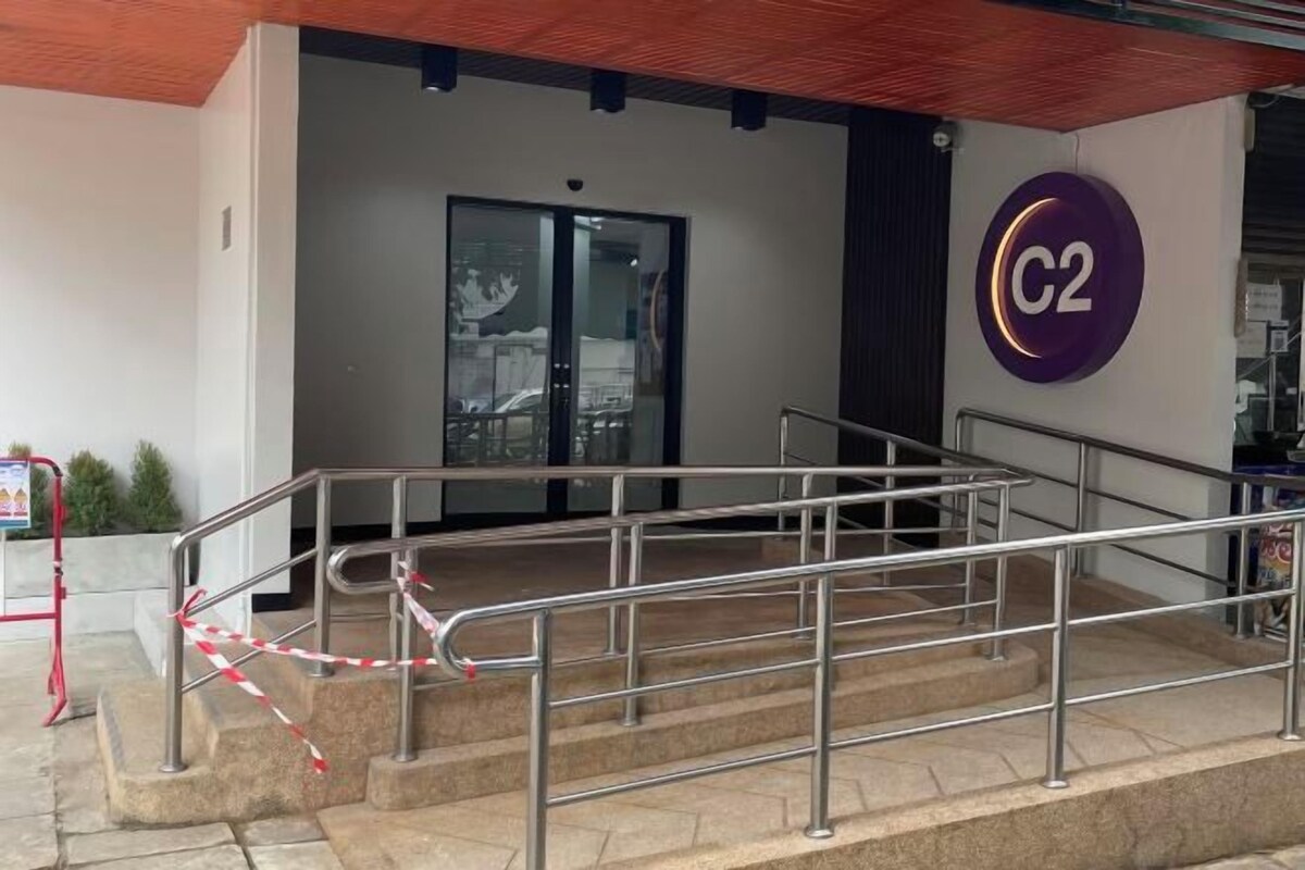 Een hotelingang met een trap, een glazen deur en een C2 sign.