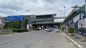 Eine mehrspurige Straße mit Hinweisschildern über dem Verkehr, ein Fußweg und ein Gebäude im Bau.