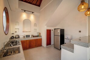Eine moderne Küche mit Granit-Arbeitsplatten, einem Einbauofen, einem Kühlschrank und einer Spüle.