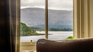 Una ventana con vistas a un lago y montañas.