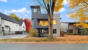 A modern two-story house with a balcony, surrounded by autumn foliage and neighboring houses. - Adventure Awaits at The Lake Loft (Coeur d`Alene)
