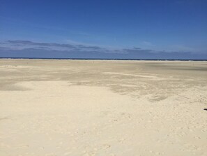 A vast, flat sandy area with a clear sky. - Exclusive 5-star apartment in an excellent location. (Borkum)