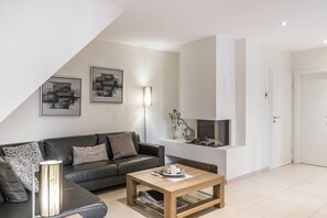 Ein modernes Wohnzimmer mit Sofa, Couchtisch und Kamin.
