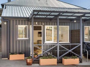 A modern building with a metal roof, large windows, and outdoor planters. - Argyle North Boutique Courtyard (North Hobart)