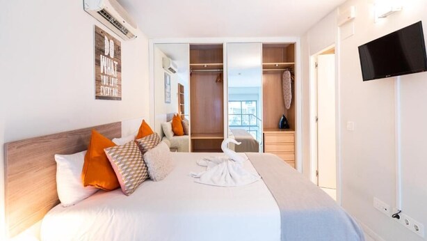 Una camera da letto con un letto grande, un armadio, una televisione e vista sull'esterno.