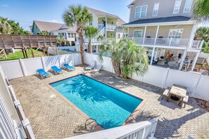 A rectangular swimming pool with a tiled edge, surrounded by a brick patio. There are lounge chairs and a small table near the pool. - Bella Sirena- 3BR/1.5BA Dog Friendly with Pool (North Myrtle Beach)