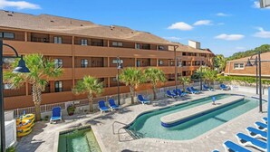 A hotel with a pool area, including lounge chairs and a small pool. - Forest Dunes 204- Side Ocean View 1 Bedroom- Pool (Myrtle Beach)