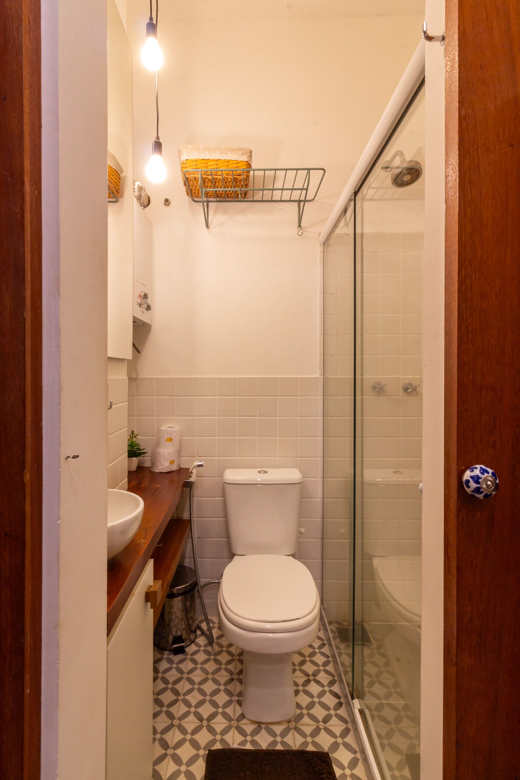 A compact bathroom with a toilet, sink, and shower.