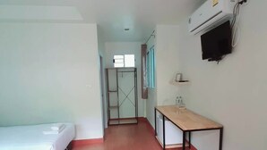 A hotel room with a bed, a desk, a TV, and a wardrobe. - Phenwaree Amphawa Resort by Zuzu (Samut Songkhram)
