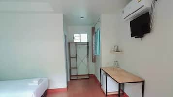 A hotel room with a bed, a desk, a TV, and a wardrobe.