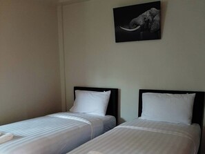 A hotel room with two single beds, plain walls, and a framed picture of an elephant. - Phenwaree Amphawa Resort by Zuzu (Samut Songkhram)