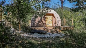 A dome-shaped cabin with a wooden door, surrounded by trees and a stone pathway. - Air-conditioned Dome & Balneotherapy (L'Escarène)