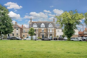 Un bâtiment à deux étages de style architectural traditionnel, doté d’une entrée centrale avec un ensemble de doubles portes et d’un petit porche.