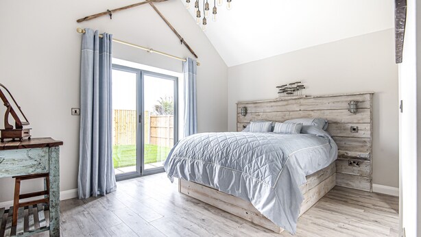 A bedroom with a bed, a desk, and a large window. - Olive's Cottage - sleeps 6 guests  in 3 bedrooms (Burnham Market)