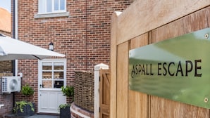 Un cancello di legno con un cartello che riporta la scritta 'Aspall Escape'.