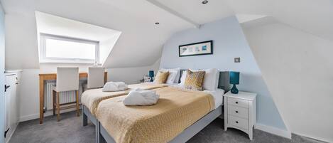 Une chambre à coucher avec un lit, un bureau et une chaise.