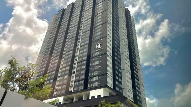 Un immeuble de grande hauteur, doté de nombreux étages et arborant un logo bien visible sur sa façade.